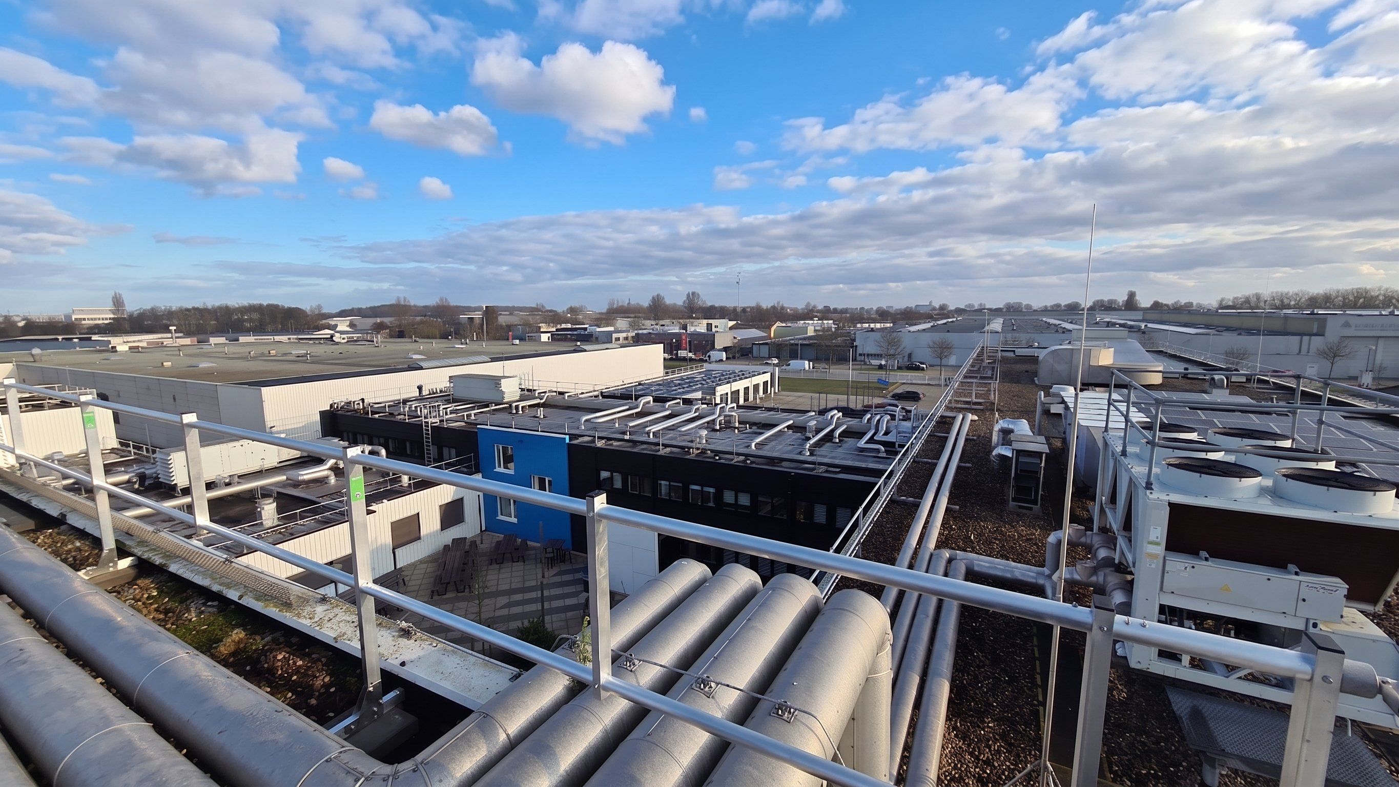 Rooftop plant and pipework on the Agilent complex, enclosed by Protector Guardrail roof-edge protection.