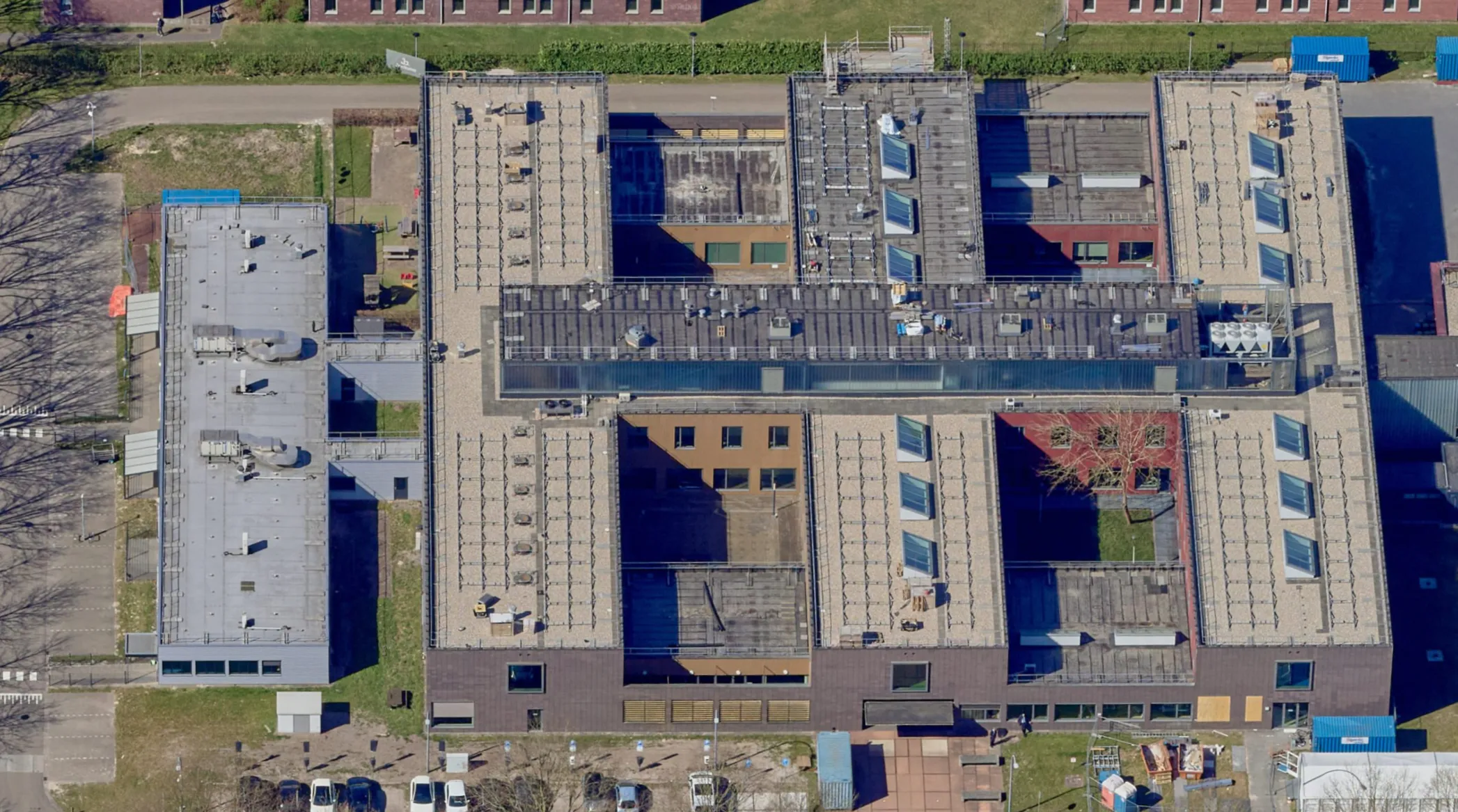 Top-down aerial view of the IND complex in Ter Apel, showing the flat roofs and courtyards of the buildings with Protector Guardrail roof-edge protection along the roof perimeters.