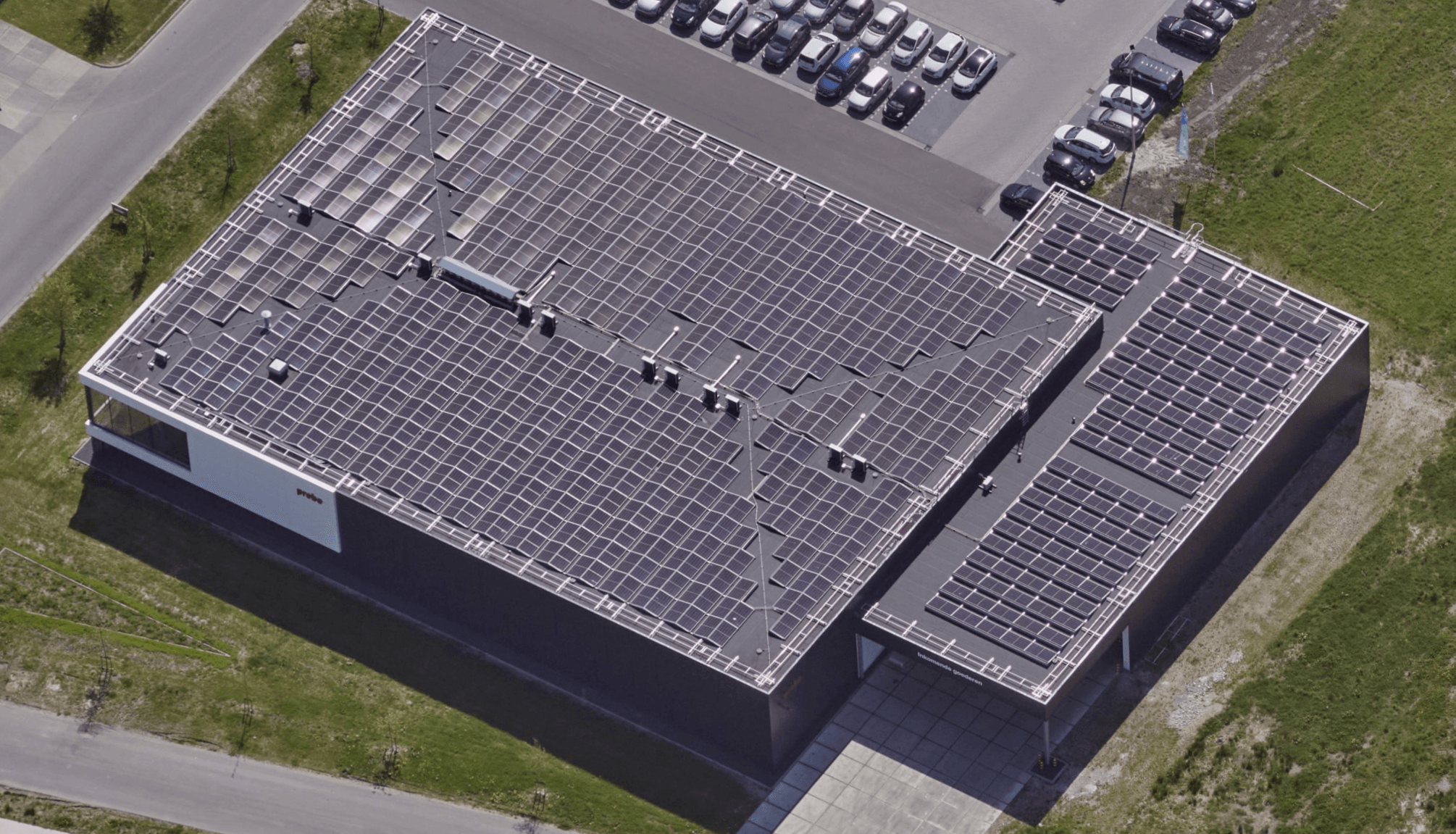 Oblique aerial view of the Probo production building with solar panels on the roof and Protector Guardrail roof-edge protection along the edge.